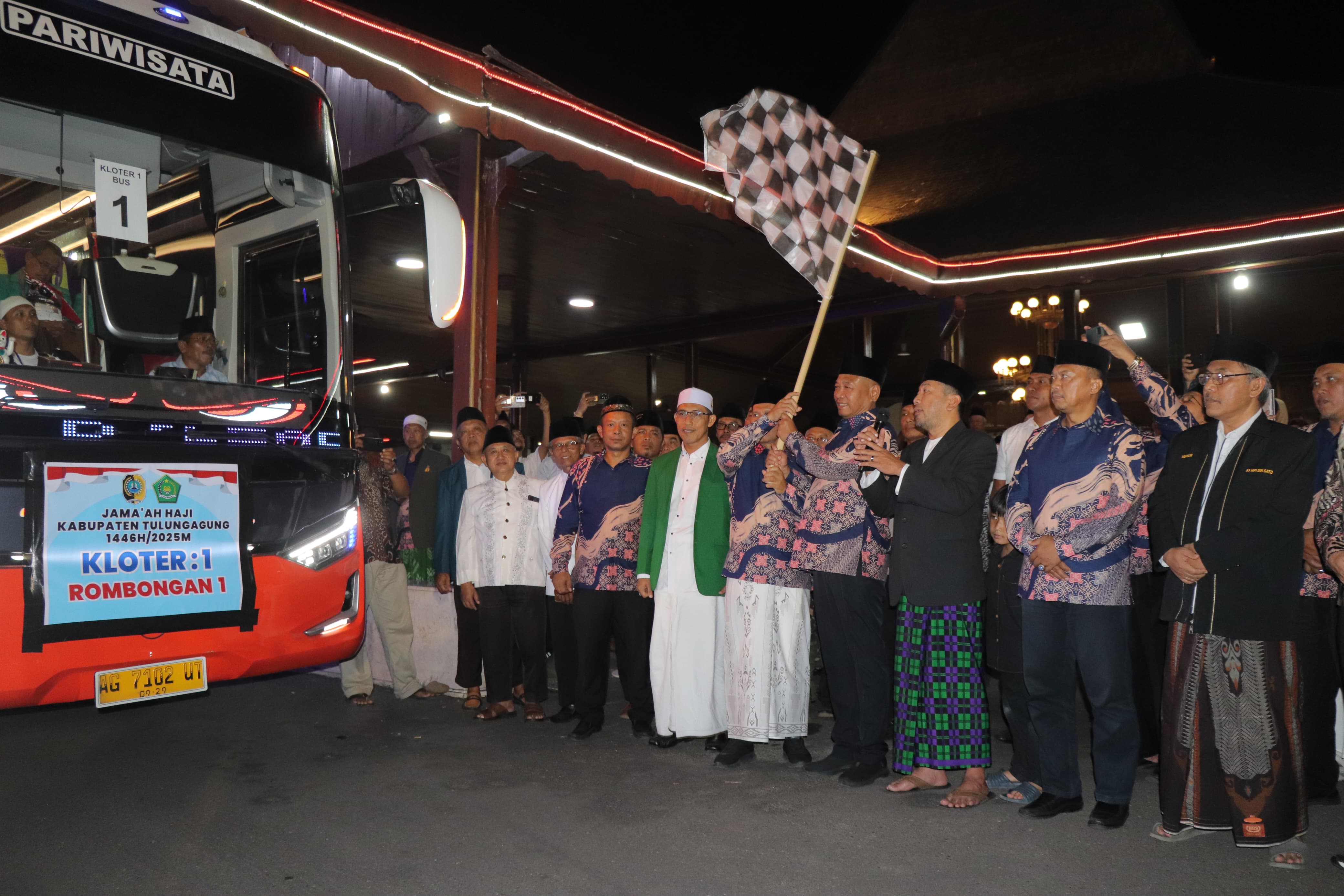 Bupati Tulungagung Gatut Sunu Wibowo mengibarkan bendera start tanda pemberangkatan JCH Tulungagung pada Kamis dini hari. (SANDY YUWANA/RADAR TULUNGAGUNG)