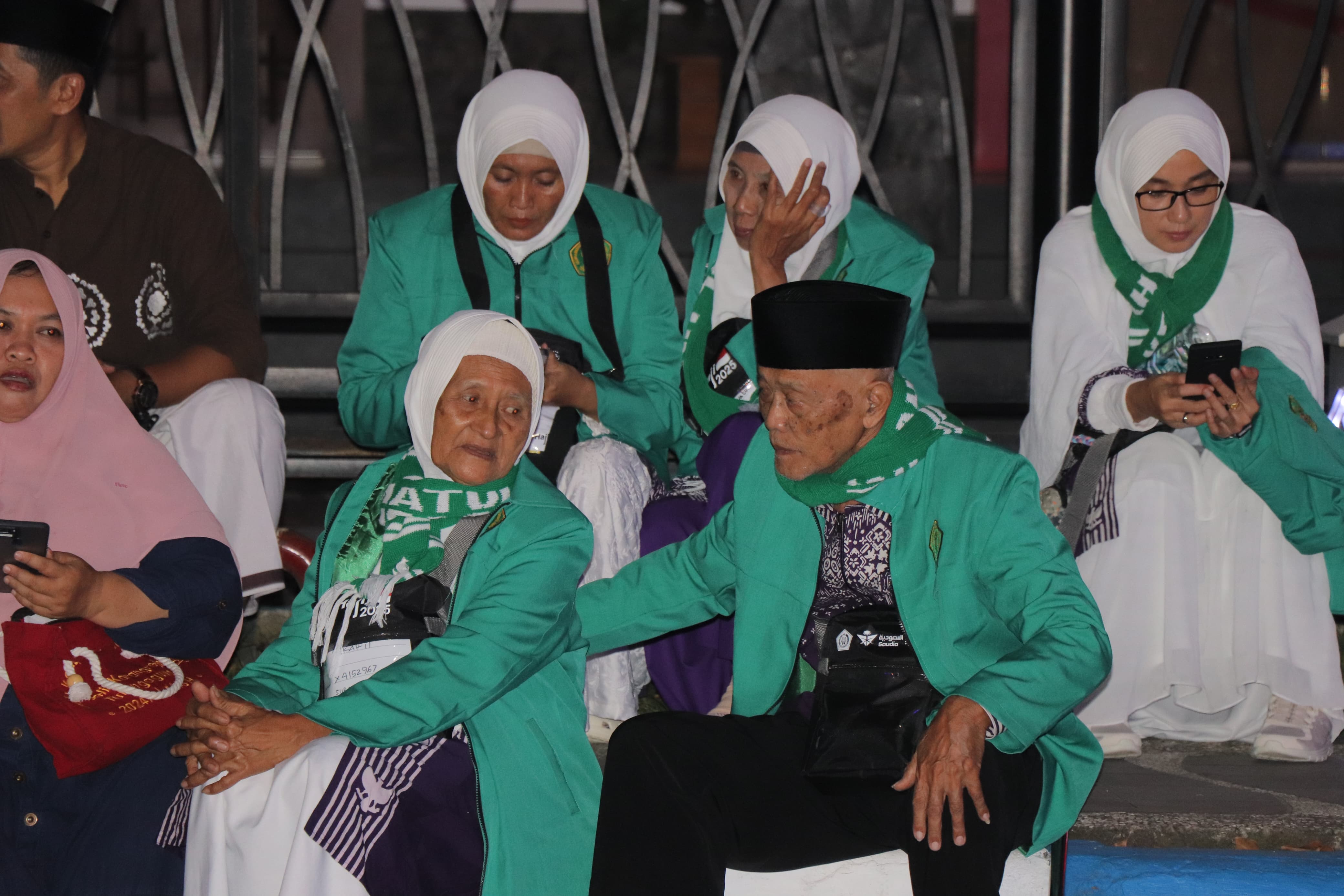 Dua JCH sepuh asal Tulungagung sedang menunggu pemberangkatan menuju Asrama Haji Sukolilo, Surabaya, pada Rabu (30/4) malam.(SANDY YUWANA/RADAR TULUNGAGUNG)