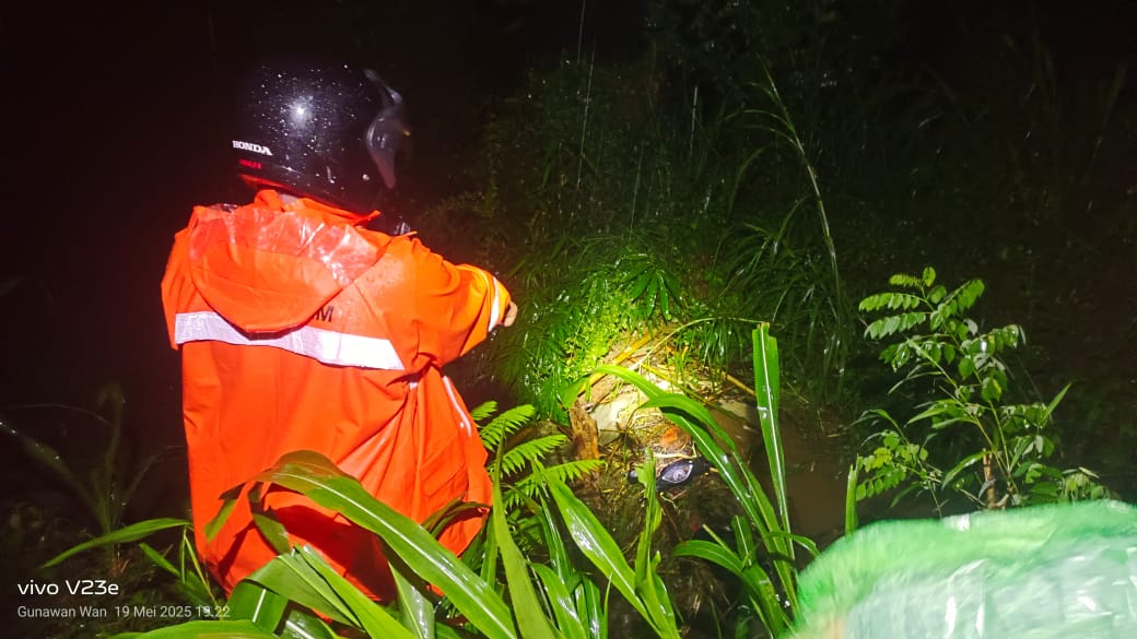 Petugas menunjukkan lokasi penemuan motor yang dikendarai Eti dan putrinya saat hilang terseret banjir pada Senin (19/5) sore.