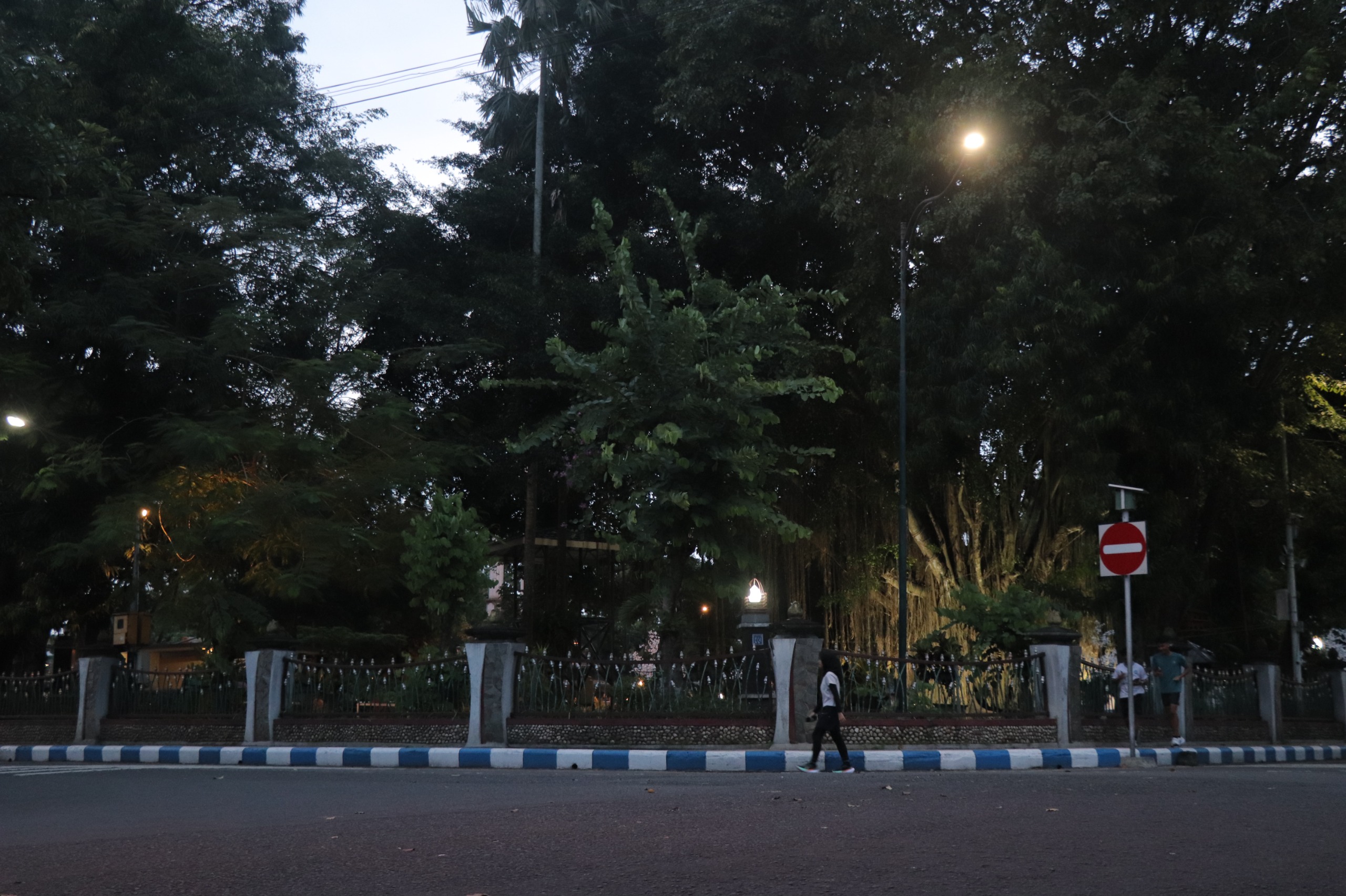 Warga melintas di area Taman Aloon-Aloon pada Kamis (23/5) petang.
