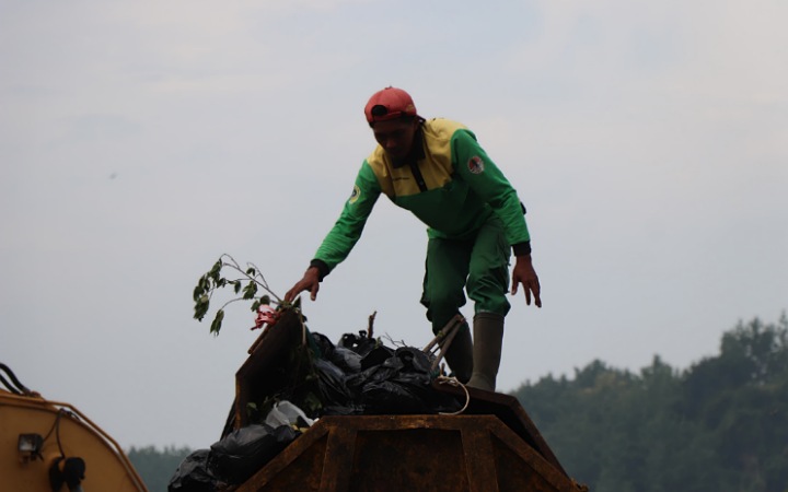 Petugas kebersihan DLH Tulungagung sedang memantu tumpukan sampah di TPA Segawe.