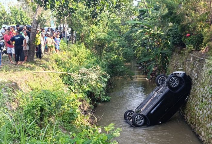 Mobil anggota DPRD Tulungagung fraksi Hanura, Subani Sirab, nyungsep ke sungai usai terlibat kecelakaan.