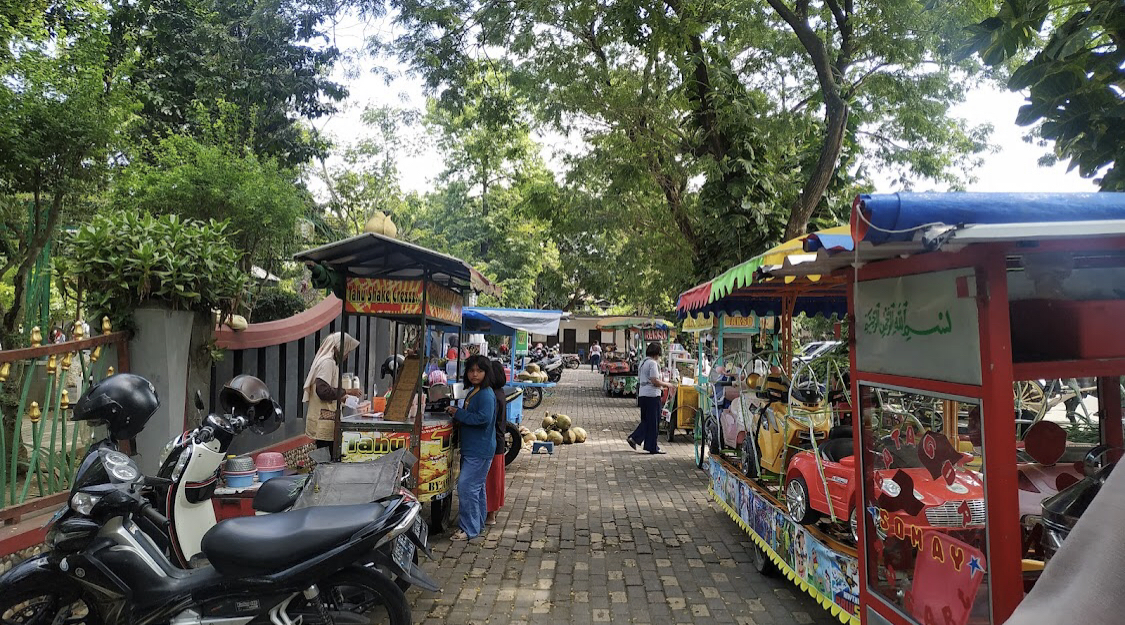 Aktivitas pedagang kaki lima di sekitar Alun-Alun Tulungagung saat hari libur. Peningkatan pengunjung membuat omzet pedagang meningkat.