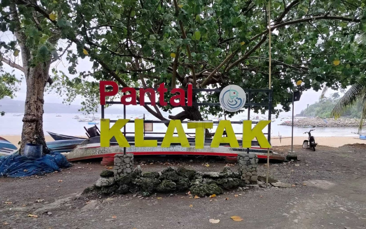Suasana alami Pantai Klatak dengan latar batu karang dan ombak yang tenang, cocok untuk relaksasi dan berkemah.