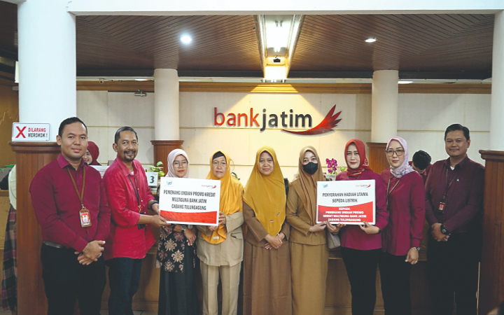 Pimpinan Bank Jatim Tulungagung, Rachmat Hadi Kusumo menyerahkan simbolis hadiah kepada nasabah beruntung. Pemenang undian foto bersama di depan hadiah sepeda listrik.