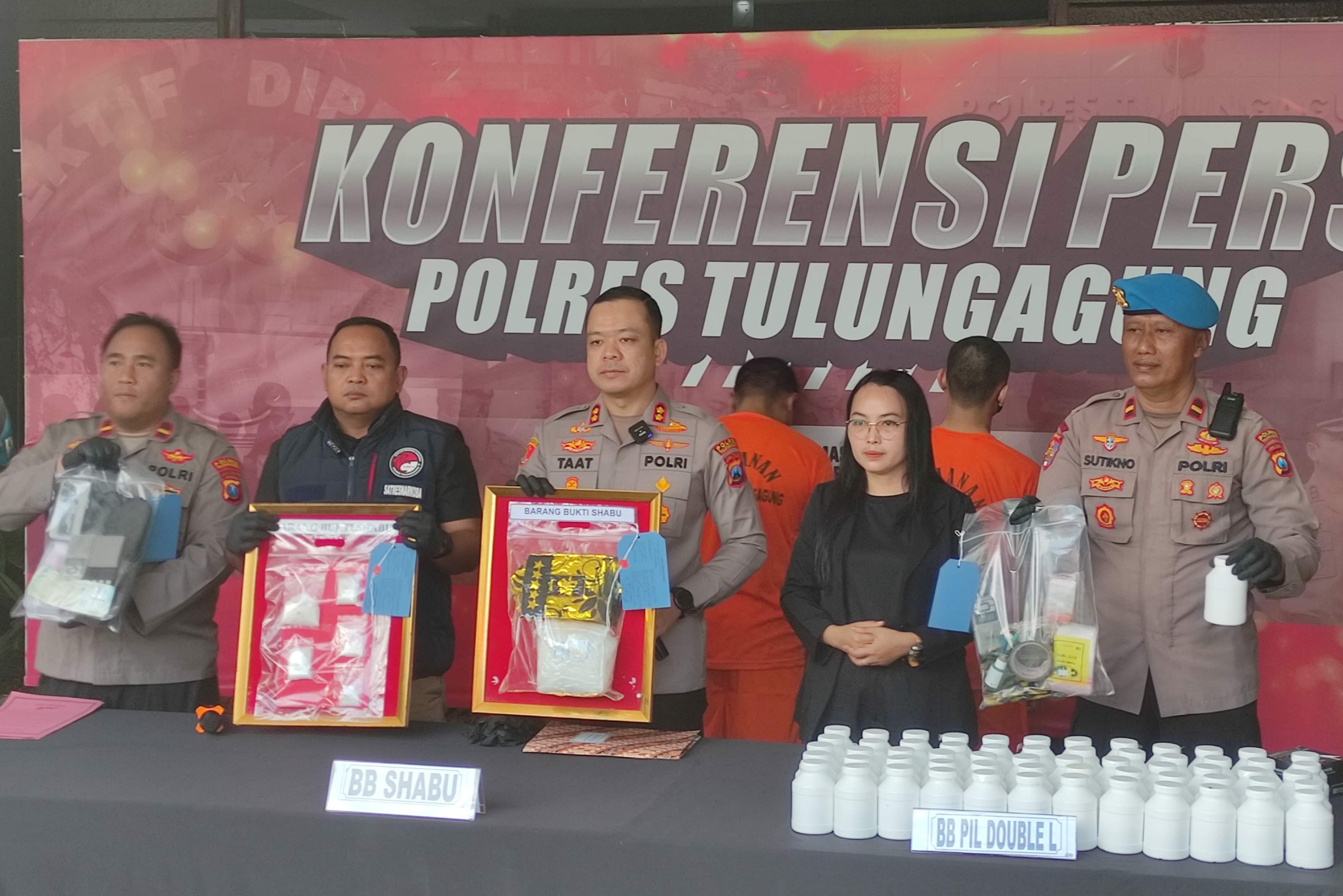 Kapolres Tulungagung AKBP Muhammad Taat Resdi menunjukkan sabu-sabu dan dobel L yang disita dari dua tersangka di rilis pers, Kamis (14/8/2025). (SANDY YUWANA/RADAR TULUNGAGUNG)