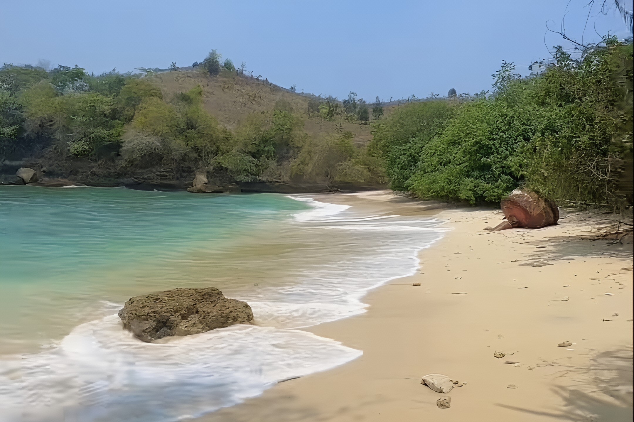 keindahan Pantai Sawahan Ombo di Tulungagung, pantai tersembunyi dengan gradasi laut toska, pasir putih bersih, dan suasana sunyi alami. Cocok untuk healing dan petualangan alam.