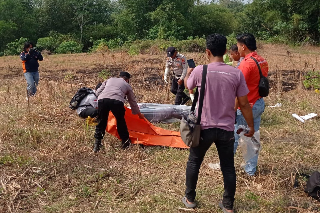 Polisi saat mengevakuasi jasad SH yang tergeletak di persawahan Desa Bolorejo, Kecamatan Kauman, Tulungagung. (POLSEK KALANGBRET)