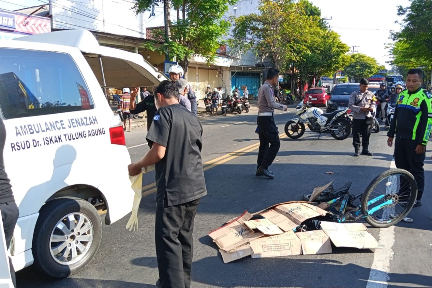 Polisi lalu lintas saat mengevakuasi jenazah Martiono yang terlibat kecelakaan lalu lintas di Jalan I Gusti Ngurah Rai. (SATLANTAS POLRES TULUNGAGUNG)