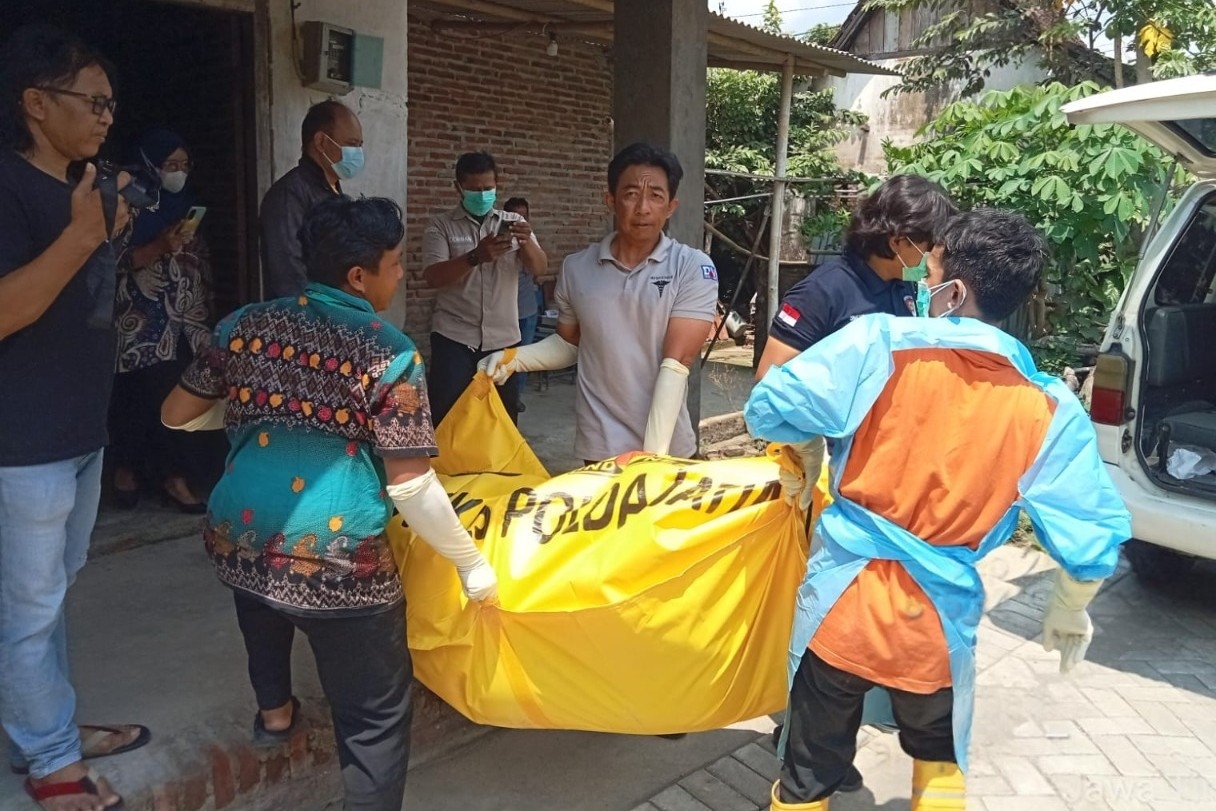 Polisi mengevakuasi jasad Tingah yang ditemukan tak bernyawa di dalam rumahnya. (POLRES TULUNGAGUNG)