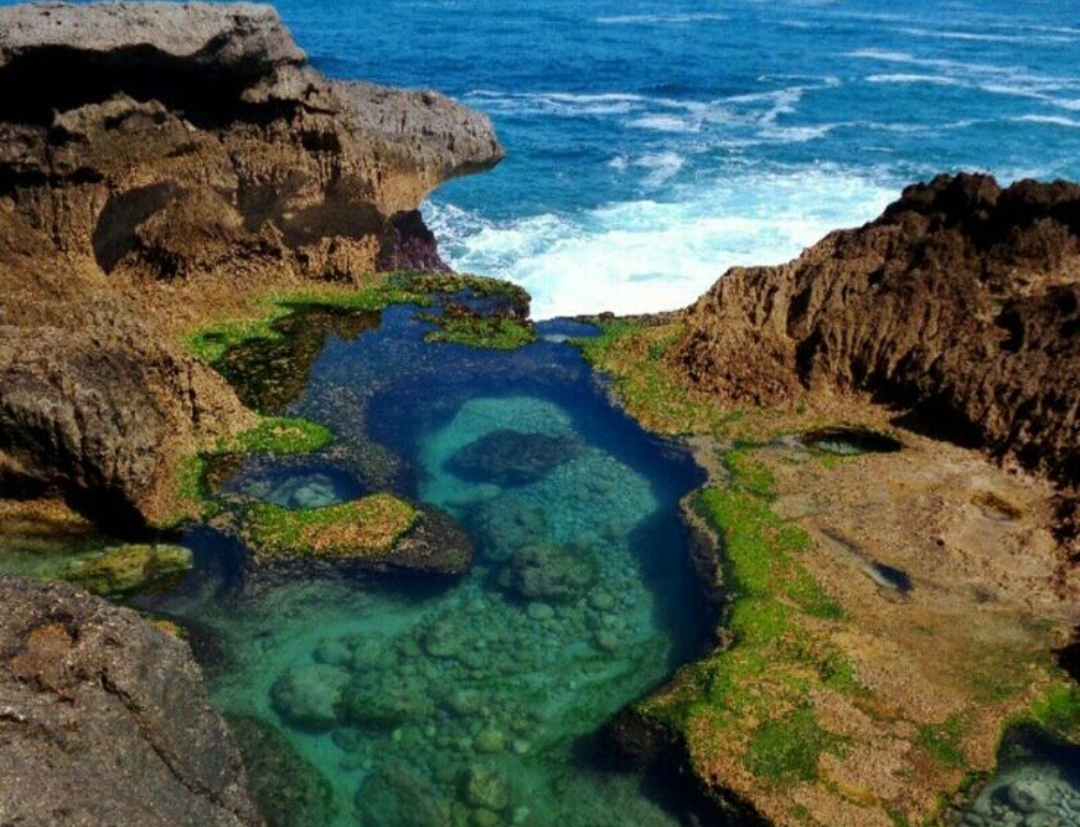 Salah satu pantai Kedung tumpang pemandangan tebing, laut biru, dan ombak besar jadi latar foto menawan.