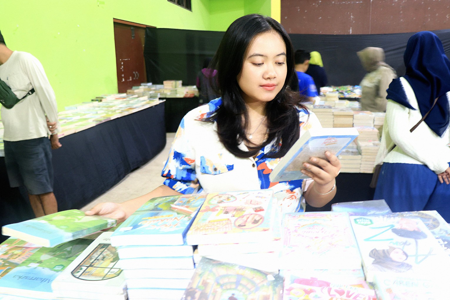 Seorang cewek melihat buku yang ditawarkan sebuah penerbit pada pameran di kantor Kelurahan Jepun. (SANDY YUWANA/RADAR TULUNGAGUNG)