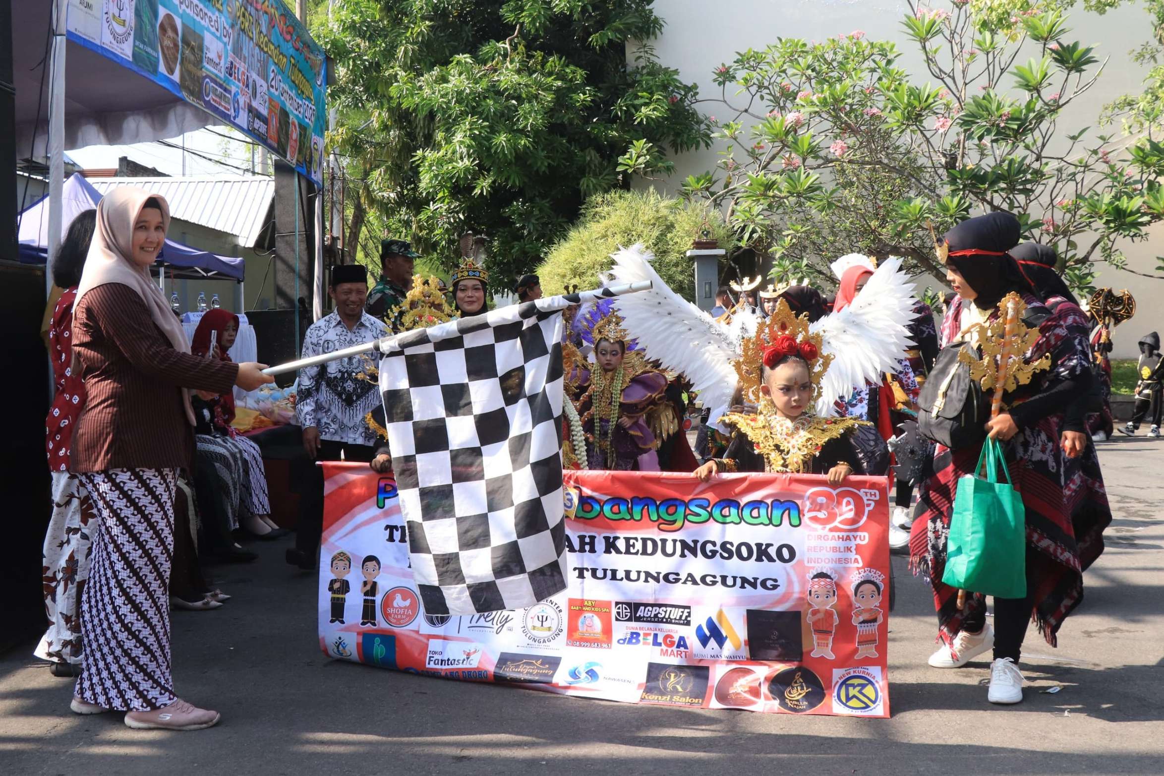 Ketua IGTKI Kecamatan Tulungagung, Dyah Tristarini mengibarkan bendera start pawai kebangsaan se-Kecamatan Tulungagung, kemarin. (SANDY YUWANA/RADAR TULUNGAGUNG)