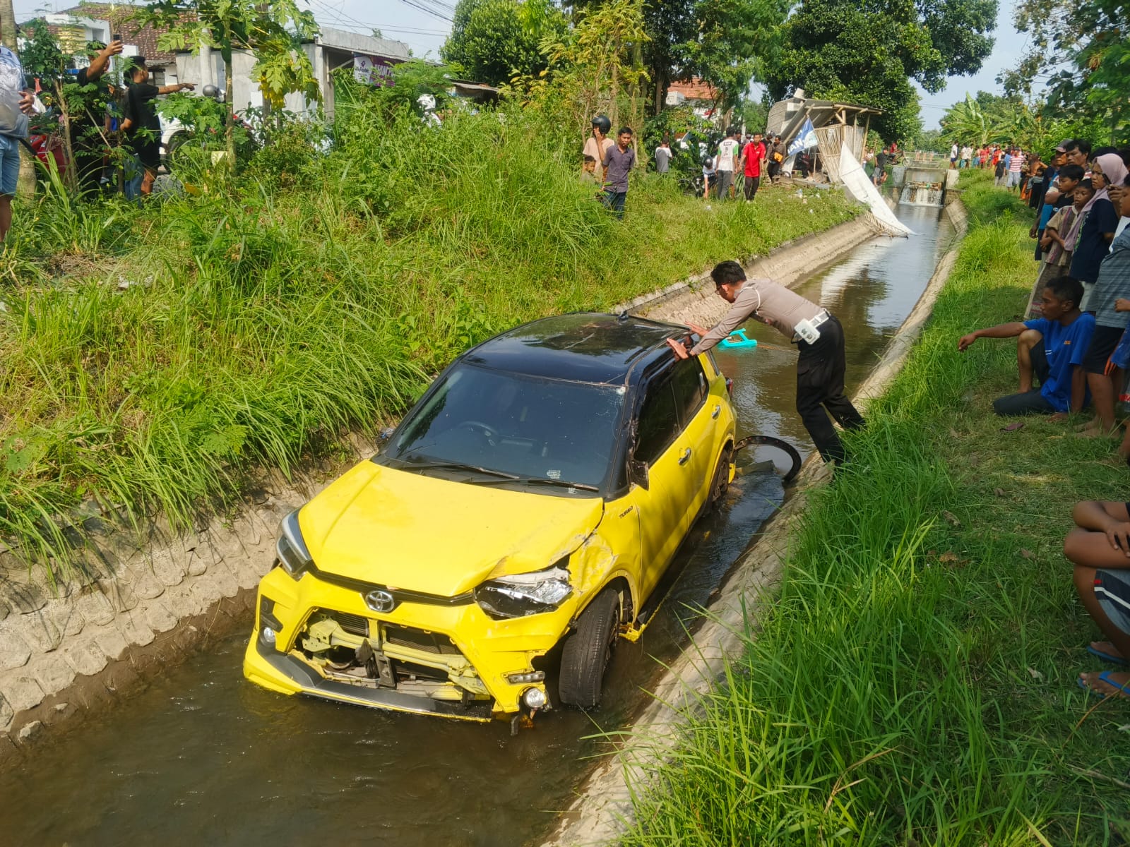 Sebuah mobil mini SUV masuk parit di Desa Jabalsari, Kecamatan Sumbergempol pada Minggu (28/9/2025). (SATLANTAS POLRES TULUNGAGUNG)