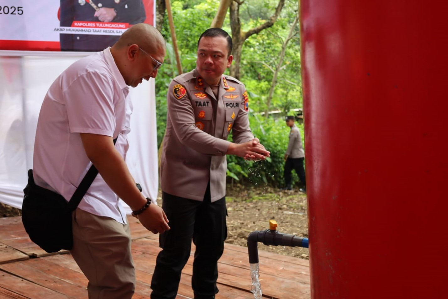 Kapolres Tulungagung AKBP Muhmmad Taat Resdi mencuci tangan dari sumur bor yang baru diresmikan.