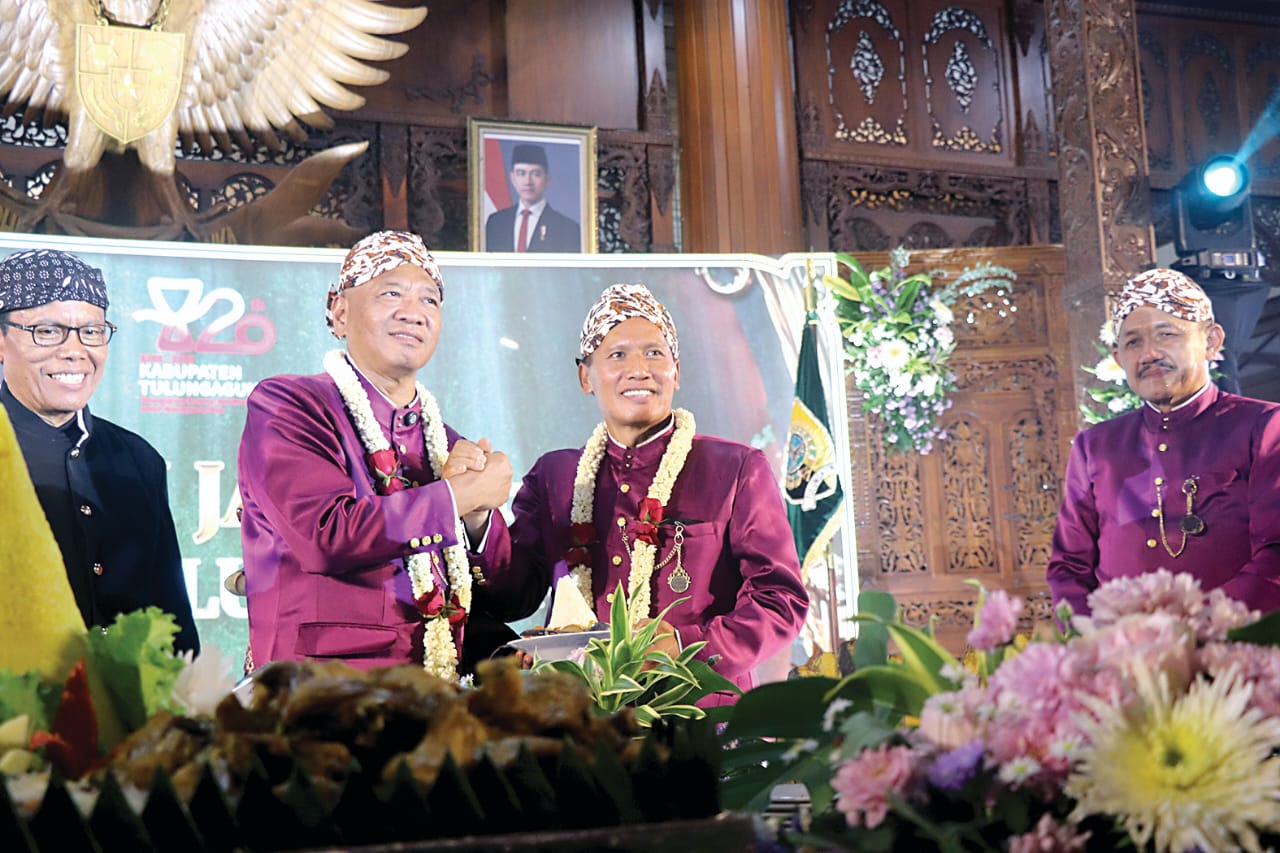 Bupati Tulungagung Gatut Sunu Wibowo menyerahkan potongan tumpeng pada Wabup Ahmad Baharudin. (DR PERDANA/RADAR TULUNGAGUNG)