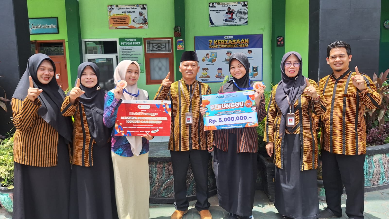 Dua siswi MTsN 1 Tulungagung meraih medali perunggu OPSI 2025, didampingi kepala madrasah dan para pembina.