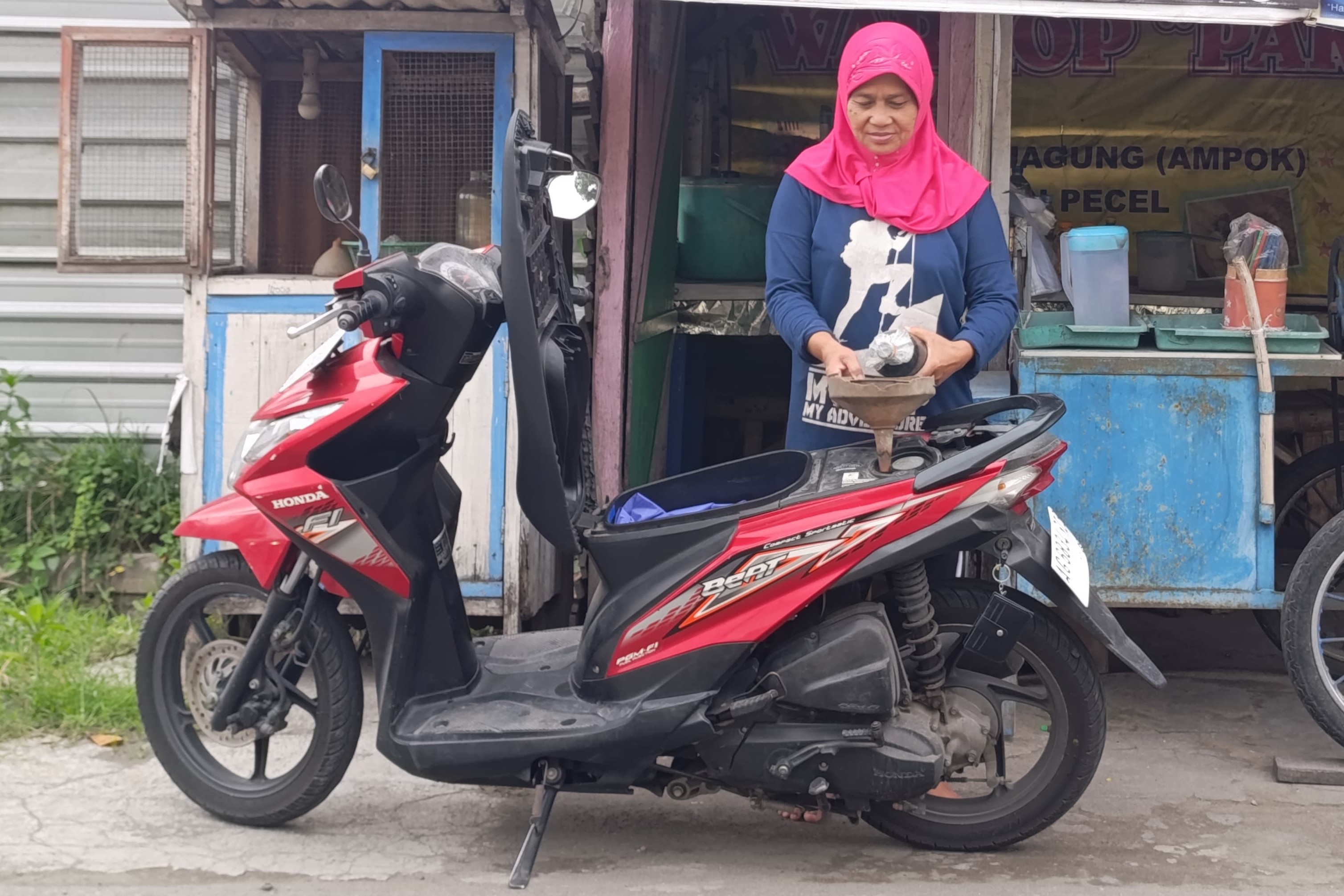 Seorang penjual bensin eceran di Kecamatan Kedungwaru melayani konsumen. (ANNIZA MEINA/RADAR TULUNGAGUNG)