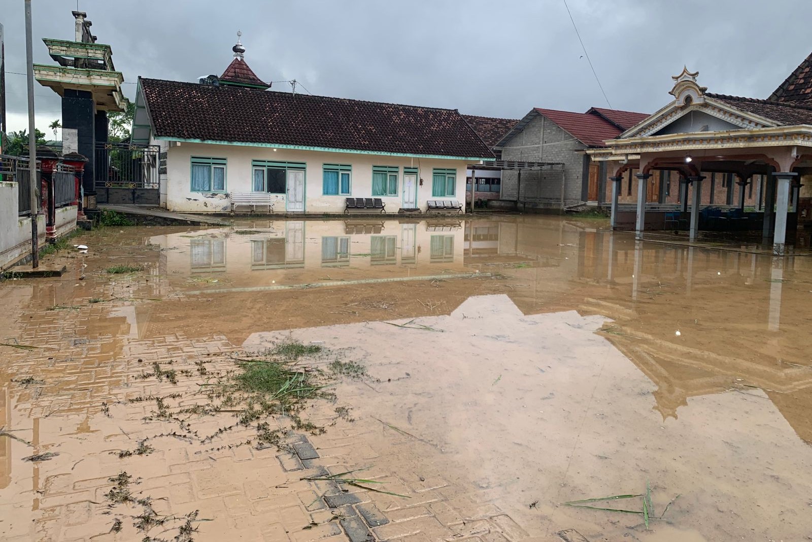 Kondisi halaman Kantor Desa Ngentrong yang dipenuhi lumpur banjir kiriman pada Kamis pagi. (SAMUJI UNTUK RADAR TULUNGAGUNG)