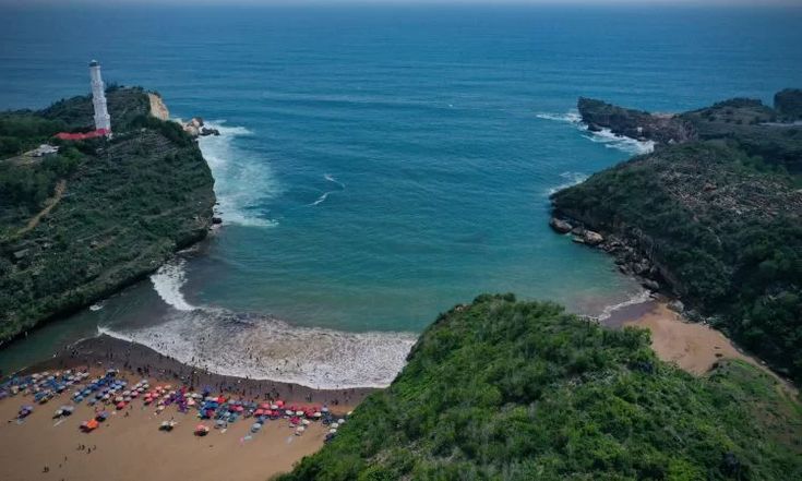 Pantai Baron Gunungkidul berubah dua warna (cokelat-biru) akibat luapan sungai bawah tanah karena hujan deras. Fenomena biasa saat musim hujan.