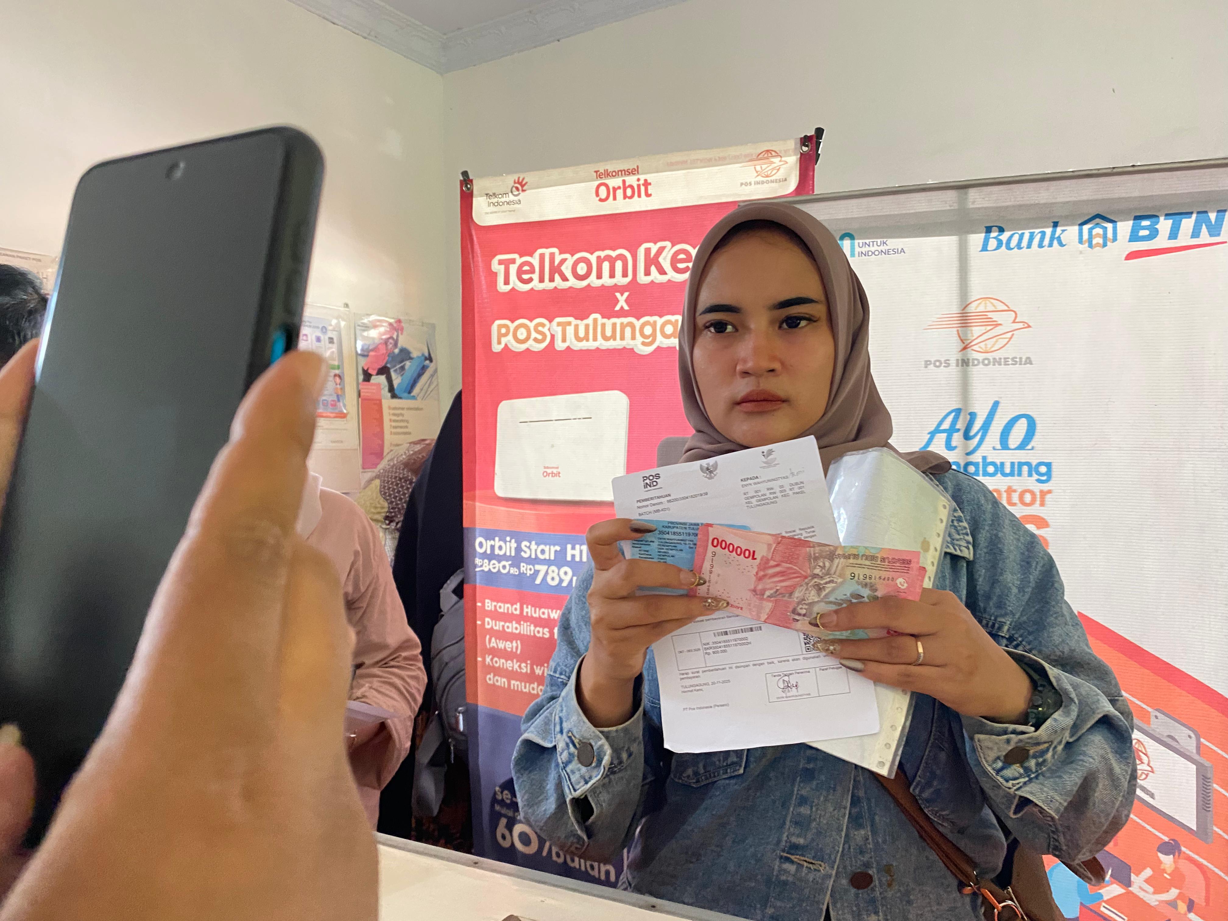 Seorang penerima BLT Kesra dari Desa Gempolan mengambil di Kantor Pos Pakel. (DR PERDANA/RADAR TULUNGAGUNG)