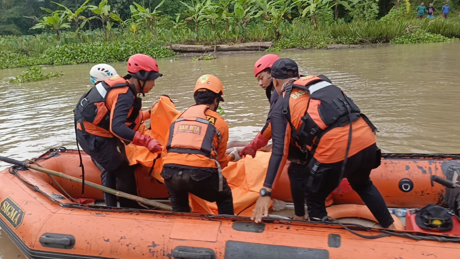 Personel SAR Trenggalek mengevakuasi jasad Rizal yang tenggelam di Sungai Bodeng pada Minggu (7/12). (SAR TRENGGALEK)