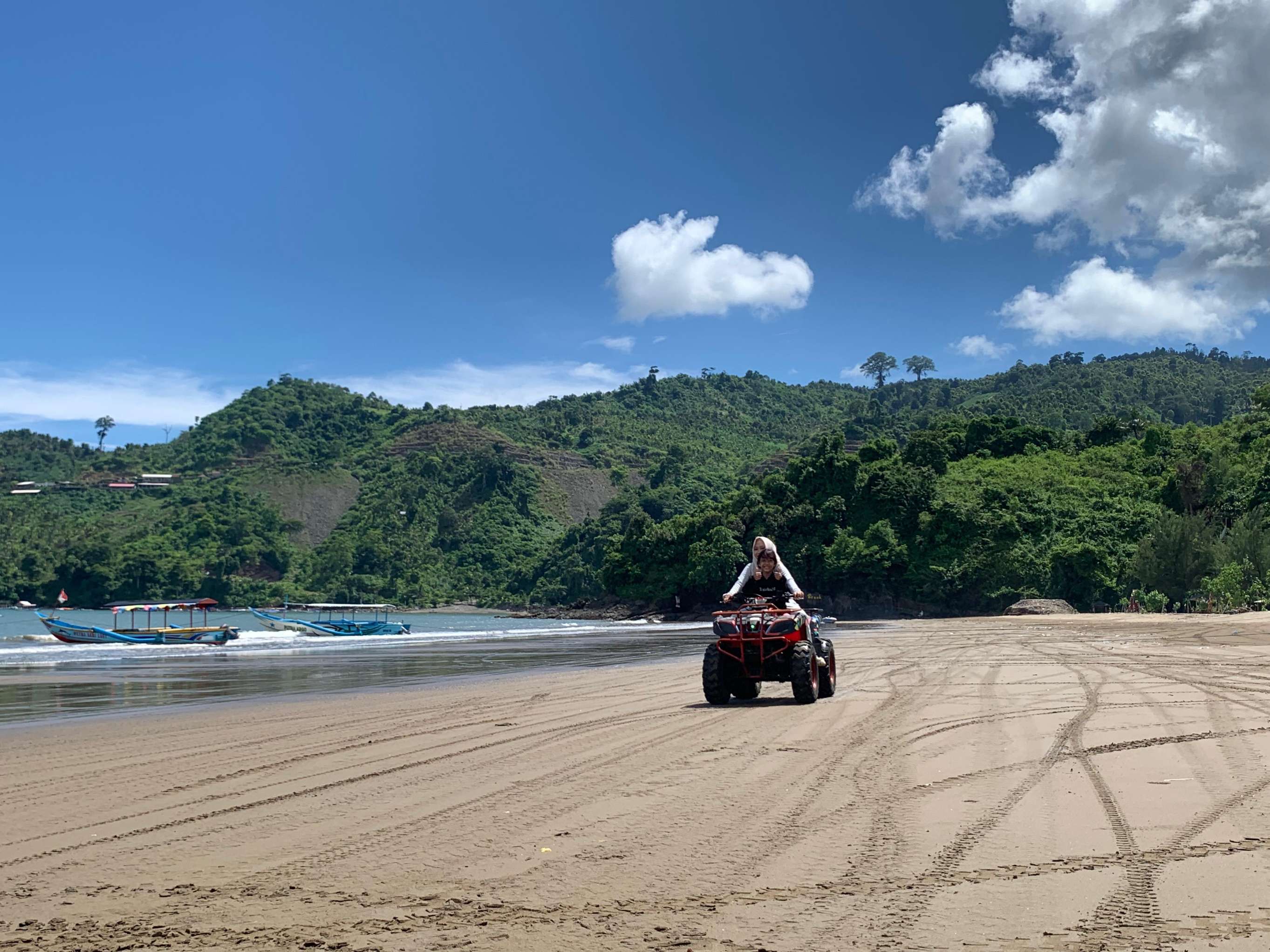 Pengunjung Pantai Gemah bermain ATV sewaan untuk mengeliling pesisir. (SANDY YUWANA/RADAR TULUNGAGUNG)