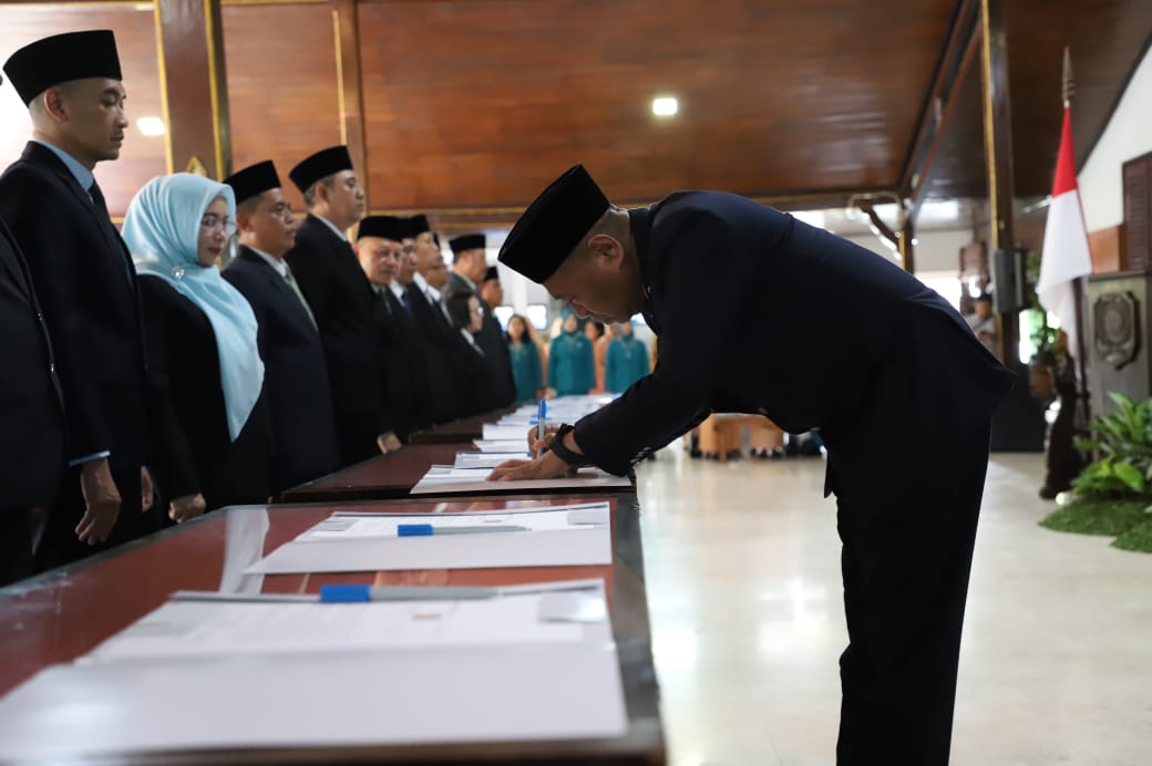 Bupati Gatut Sunu Wibowo menandatangani berkas dalam pelantikan dan pengambilan sumpah jabatan di pendapa, Kamis (11/12).