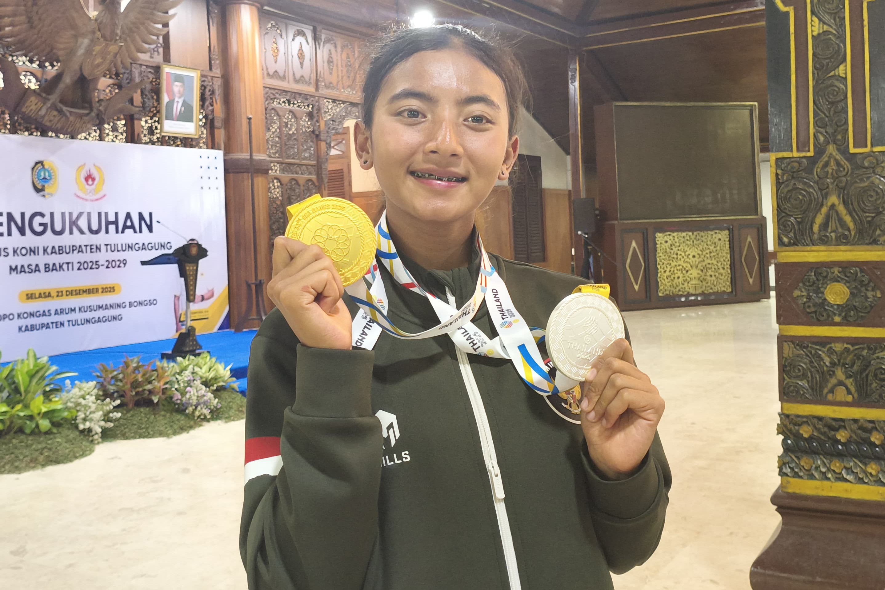 Binta Erlen Salsabela menunjukkan medali emas dan perak yang dia raih dari SEA Games 2025 di Thailand beberapa waktu lalu. (ADITYA YUDA SETYA PUTRA/RADAR TULUNGAGUNG)