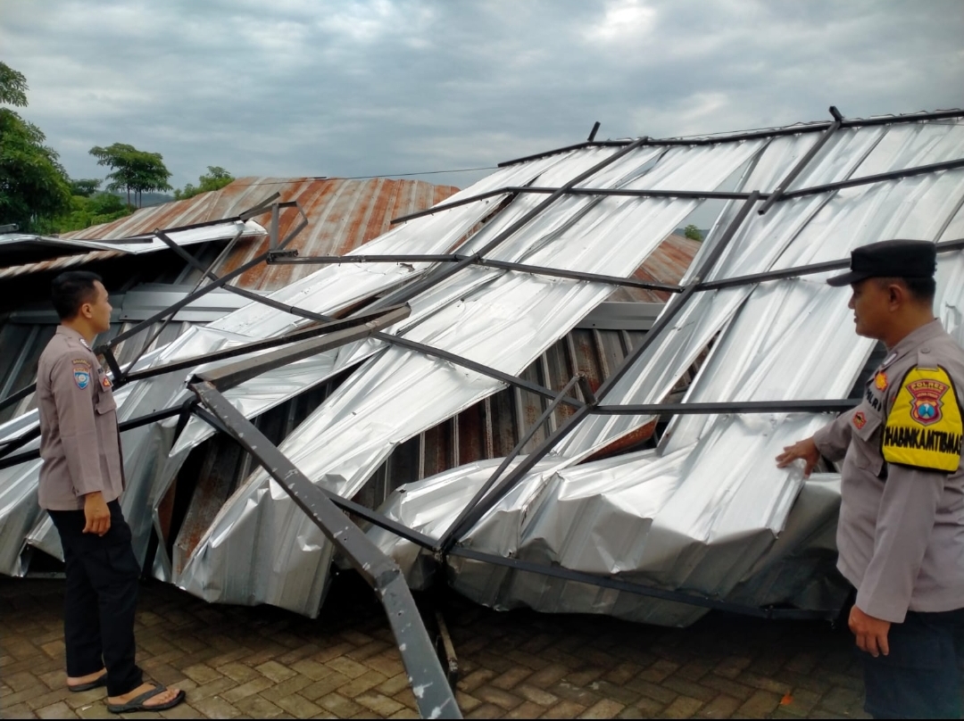 Petugas Polsek Campurdarat sedang meninjau lokasi bangunan BUMDes Tanggung yang roboh tersapu angin