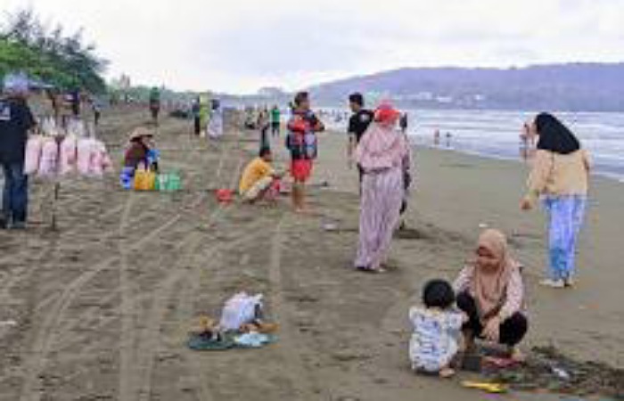 Suasana Pantai Barat Pangandaran dipadati wisatawan saat akhir pekan. Petugas Balawista berjaga dan memasang bendera merah untuk mengantisipasi wisatawan terseret arus laut