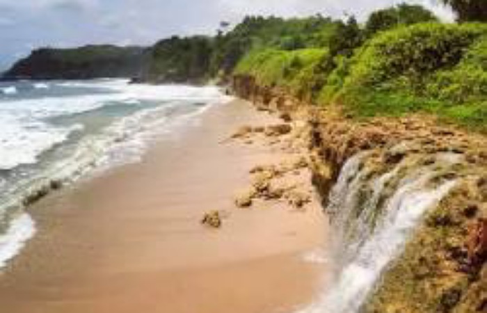 Suasana Pantai Pacar Tulungagung terbaru 2026 saat akhir pekan dipadati wisatawan. Ombak besar akibat air laut pasang membatasi aktivitas pengunjung di bibir pantai.