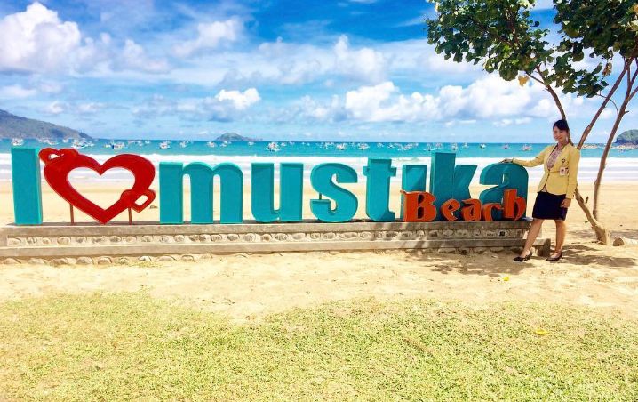 Pantai Mustika Banyuwangi dekat Pulau Merah, pasir putih 2 km, ombak tenang, sunset cantik, plus akses resmi ke Pulau Bedil.
