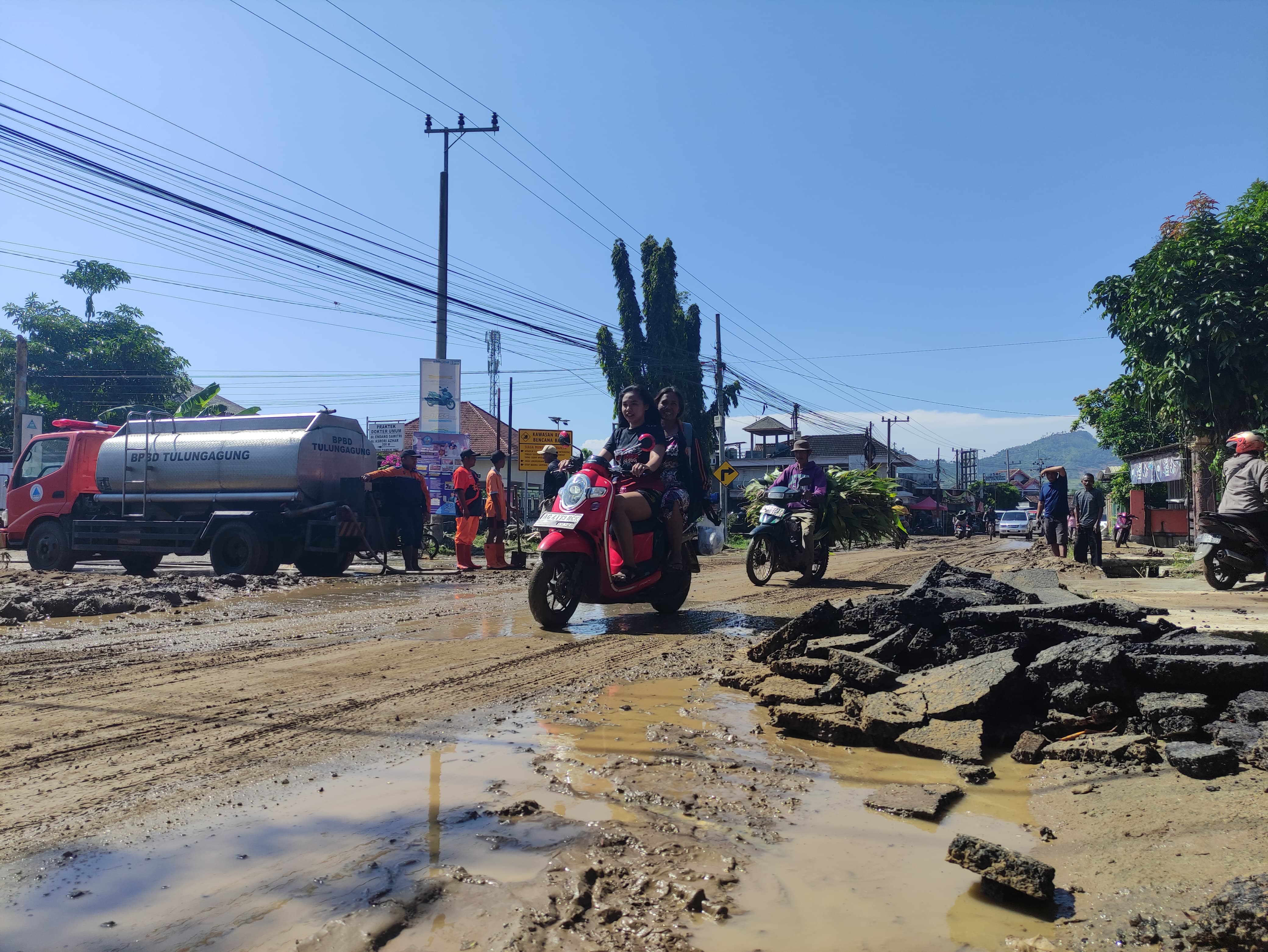 Aspal mengelupas di jalan utama Desa Besole, Kecamatan Besuki, lantaran tertimbun lumpur akibat hujan deras kemarin (30/1) malam.(SANDY YUWANA/RADAR TULUNGAGUNG)