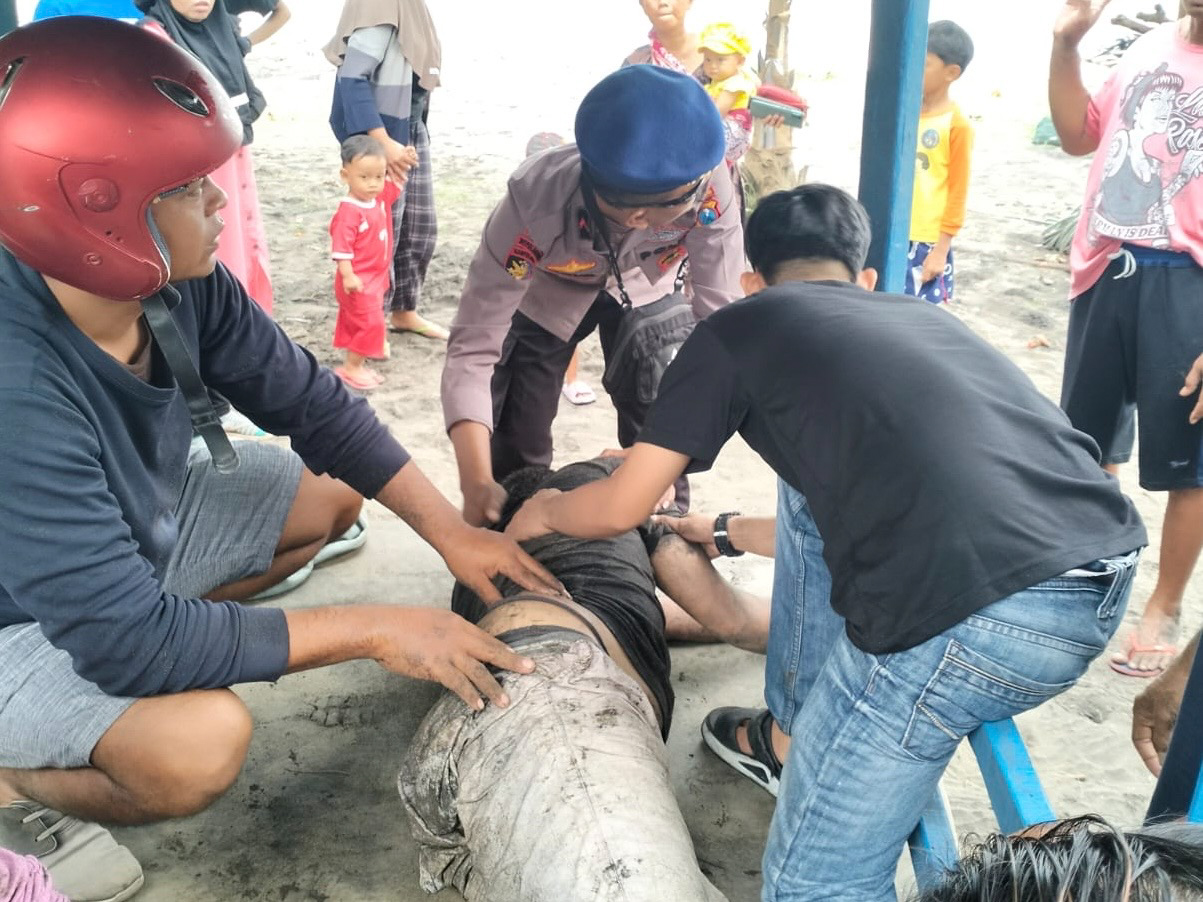 NONO UNTUK RADAR TULUNGAGUNG LEMAS: Warga membantu salah satu wisatawan yang selamat usai terseret ombak Pantai Sine pada Sabtu (7/2) siang.