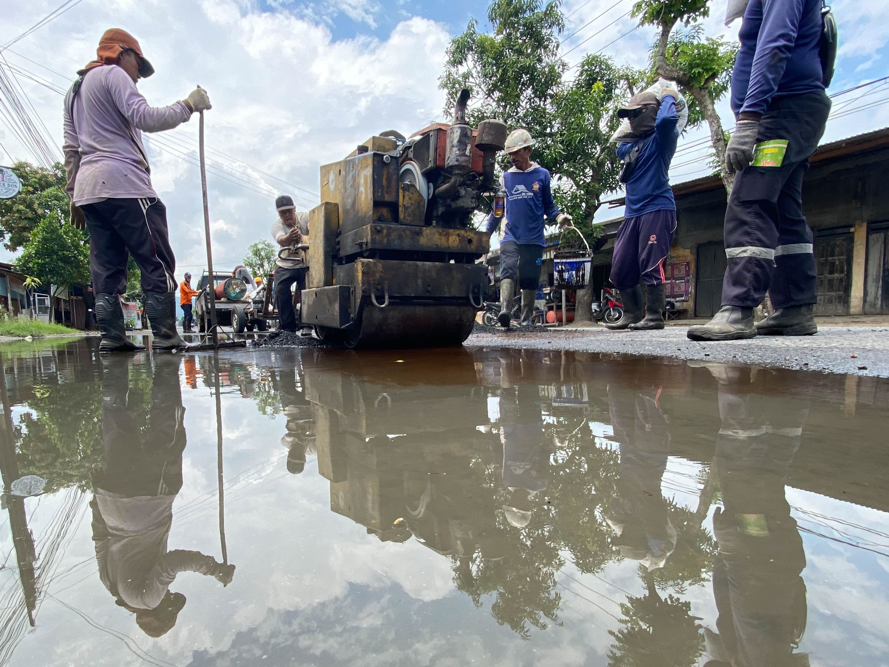 Pekerja menambal jalan berlubang di Desa Tanggung, Kecamatan Campurdarat, yang beberapa waktu lalu menimbulkan kecelakaan merenggut satu korban jiwa.(DR PERDANA/RADAR TULUNGAGUNG)