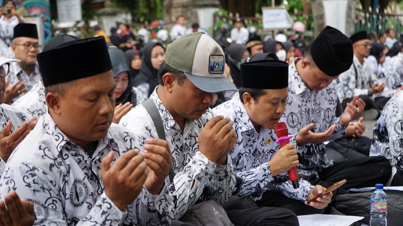 Ratusan guru dan tendik P3K paruh waktu duduk bersila di depan gedung DPRD dewan untuk menuntut kelayakan gaji.(SANDY YUWANA/RADAR TULUNGAGUNG)