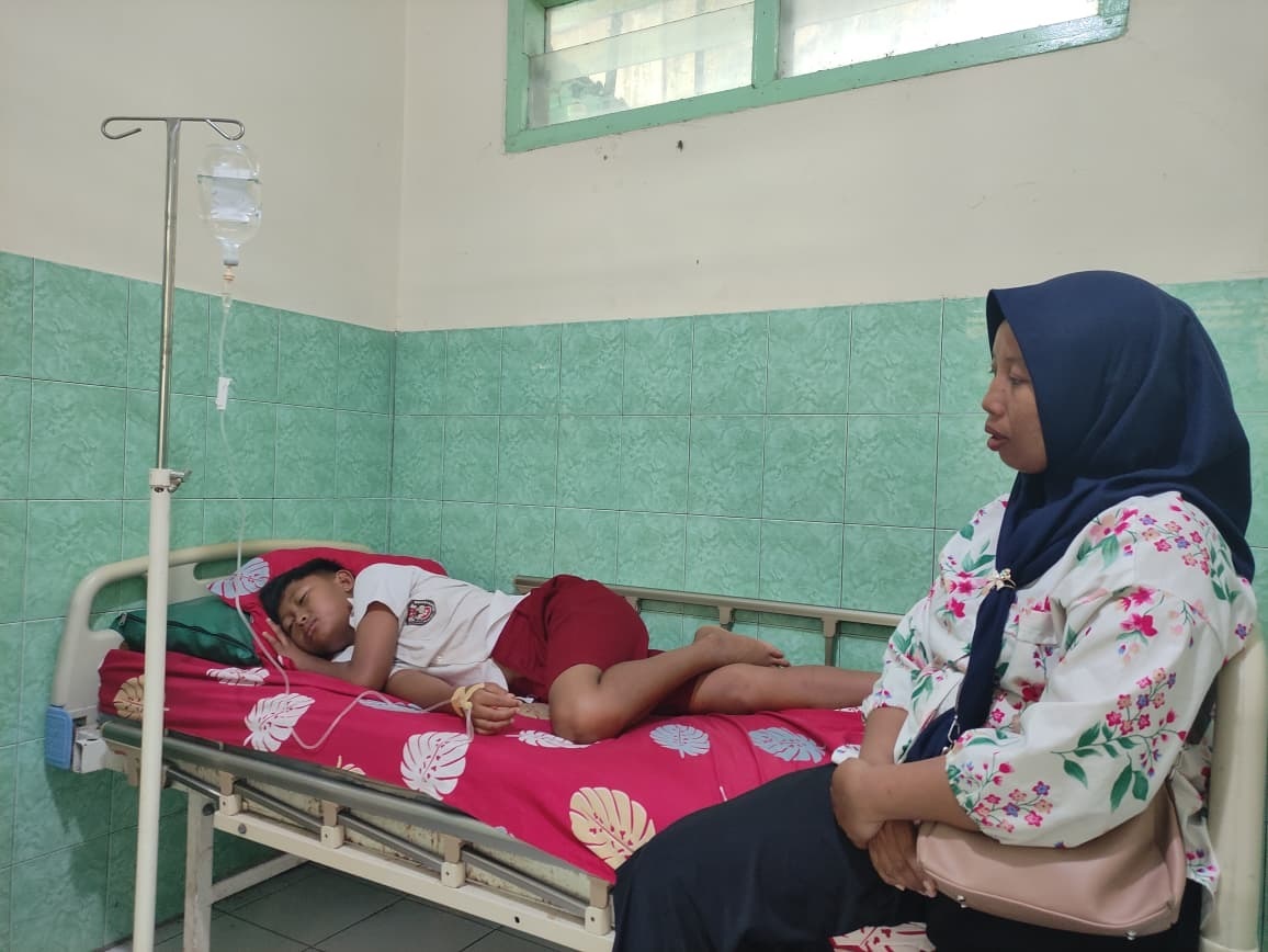 Salah satu siswa SDN 3 Bungur diduga keracunan MBG terbaring di Puskesmas Karangrejo, Selasa (10/2).(SANDY YUWANA/RADAR TULUNGAGUNG)