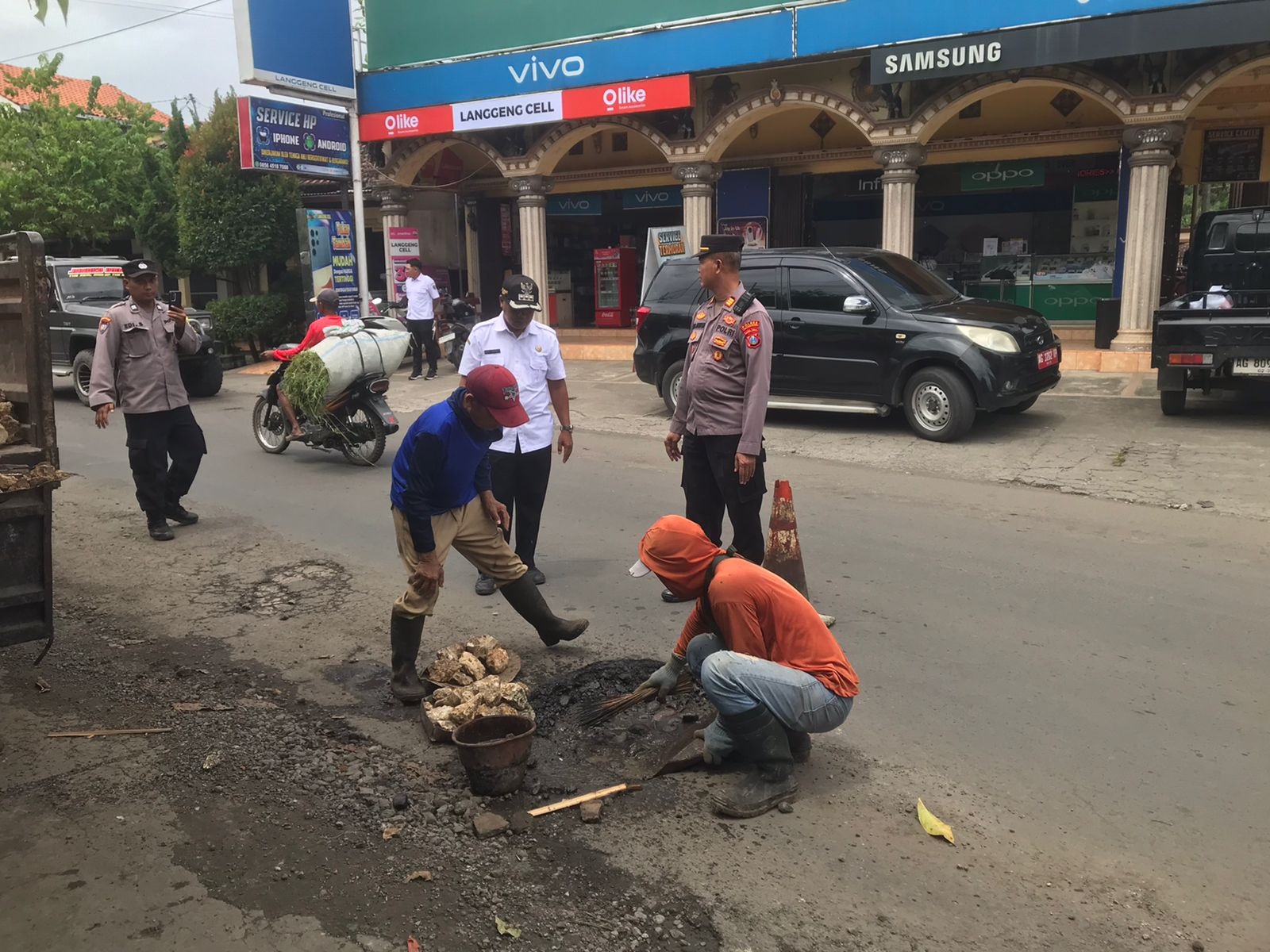 Pekerja menambal jalan berlubang di Desa Wates, Kecamatan Sumbergempol, yang selalu dikeluhkan warga.(KECAMATAN SUMBERGEMPOL UNTUK RADAR TULUNGAGUNG)