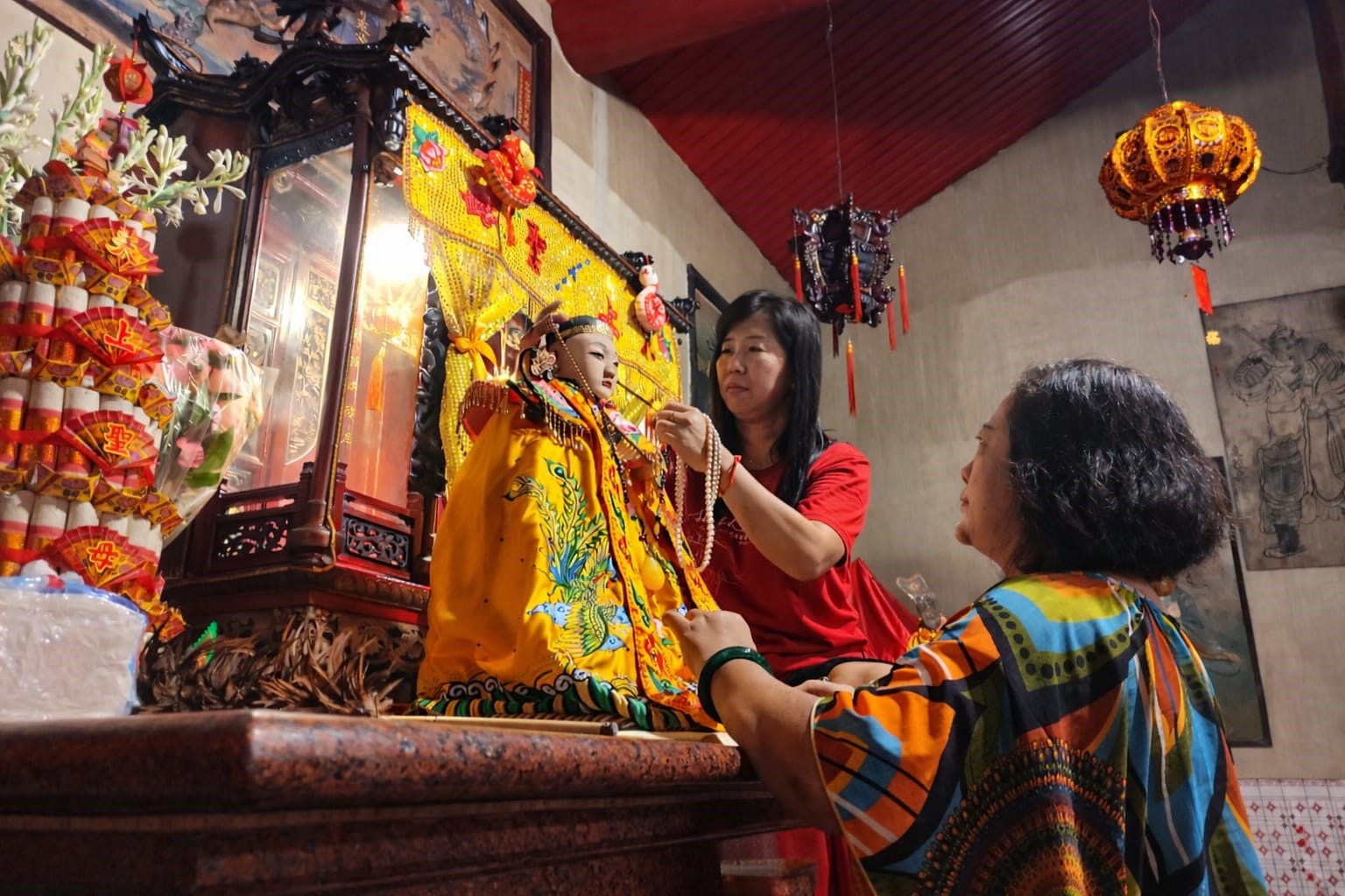 Bioma TITD Tjoe Tik Kiong Jingjing (baju merah) mengganti baju Dewa Mak Co dari kuning menjadi merah jelang perayaan Imlek.(SANDY YUWANA/RADAR TULUNGAGUNG)