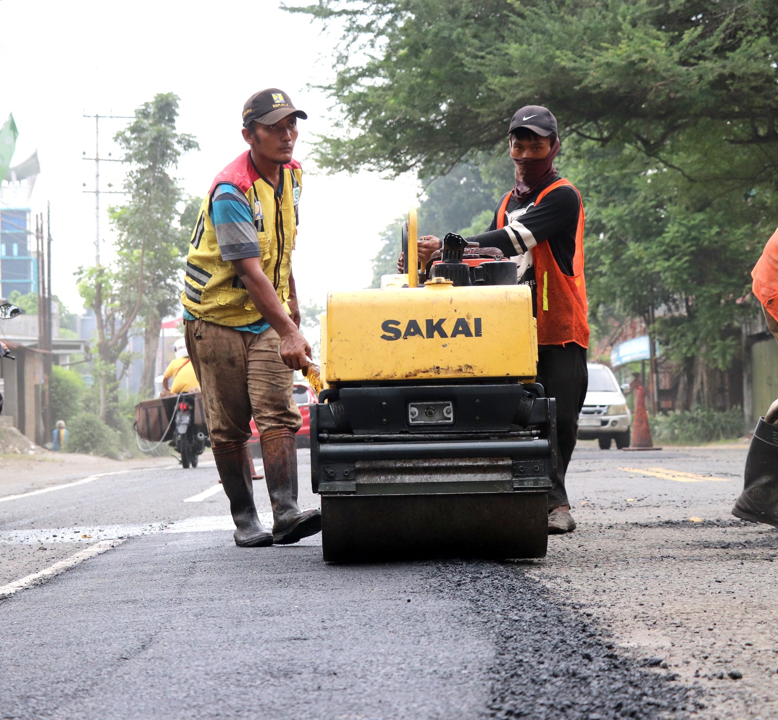 Pekerja sedang melakukan perbaikan salah satu ruas jalan di Tulungagung.