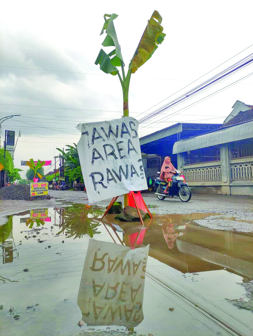 Kondisi jalan rusak di wilayah Desa Sambirobyong, Kecamatan Sumbergempol pada hari Minggu (22/2), sudah terlihat material perbaikan jalan.(SANDY YUWANA/RADAR TULUNGAGUNG)