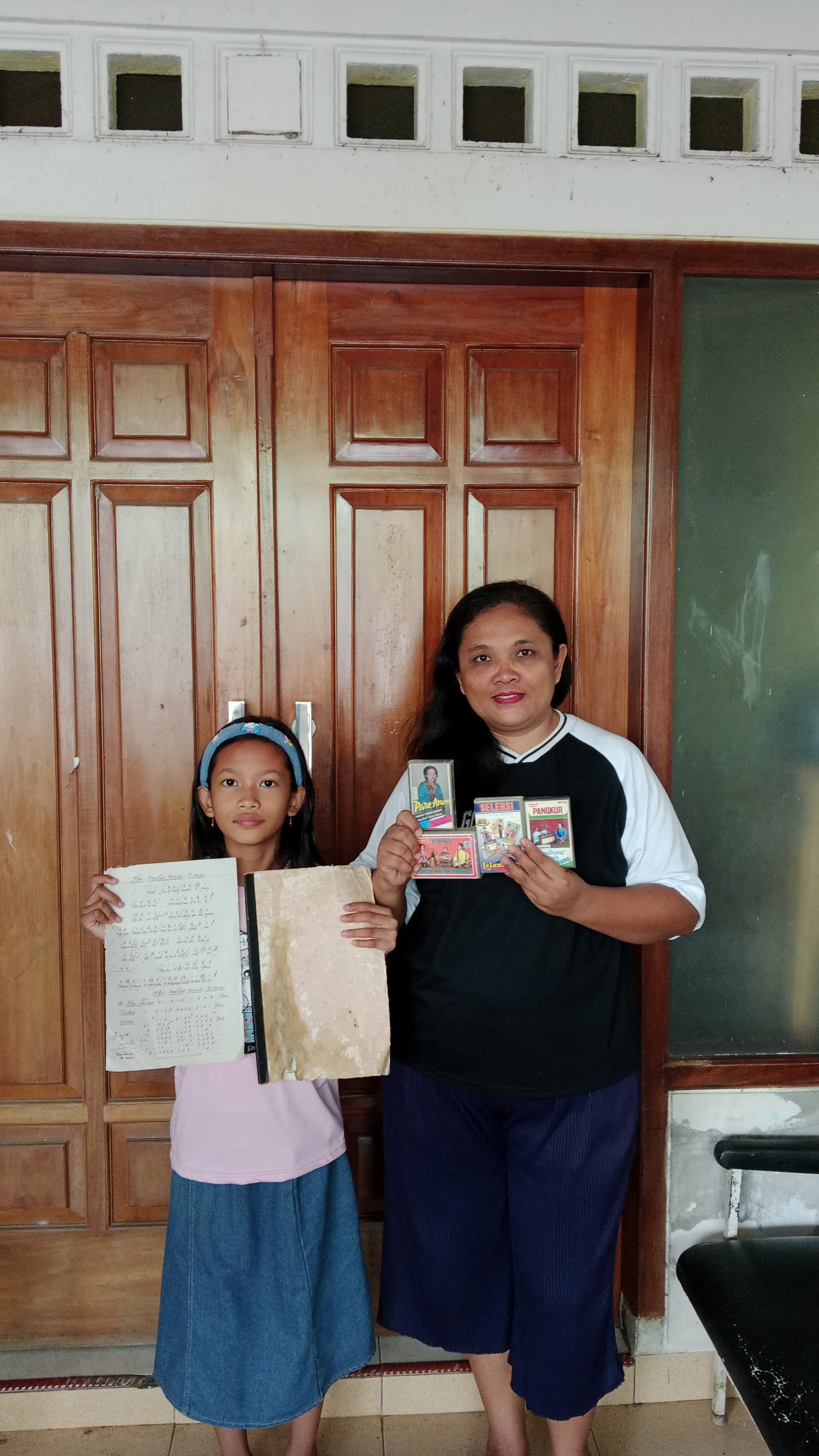 Purna Istriati (anak keempat Yono Prawito) bersama putrinya ketika menunjukkan foto-foto kenangan dari sang ayah.(SANDY YUWANA/RADAR TULUNGAGUNG)