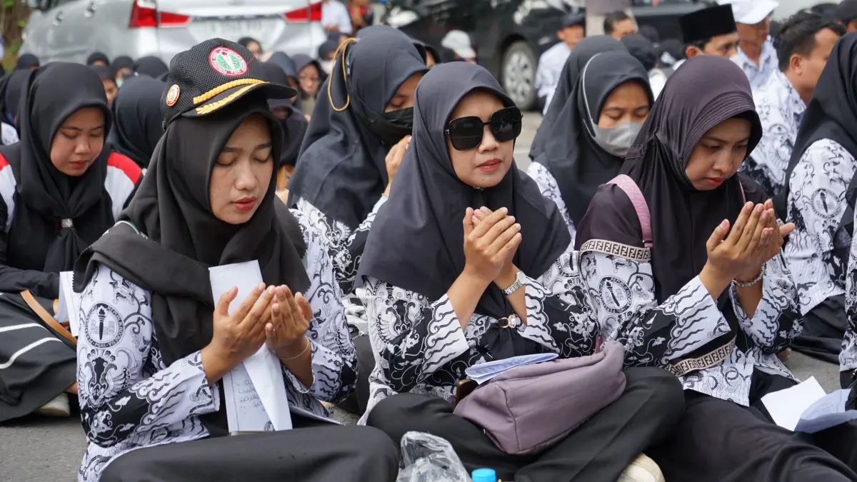 Ratusan guru dan tendik P3K paruh waktu saat duduk bersila di depan gedung DPRD dewan untuk menuntut kelayakan gaji, Rabu (11/2/2026).(SANDY YUWANA/RADAR TULUNGAGUNG)