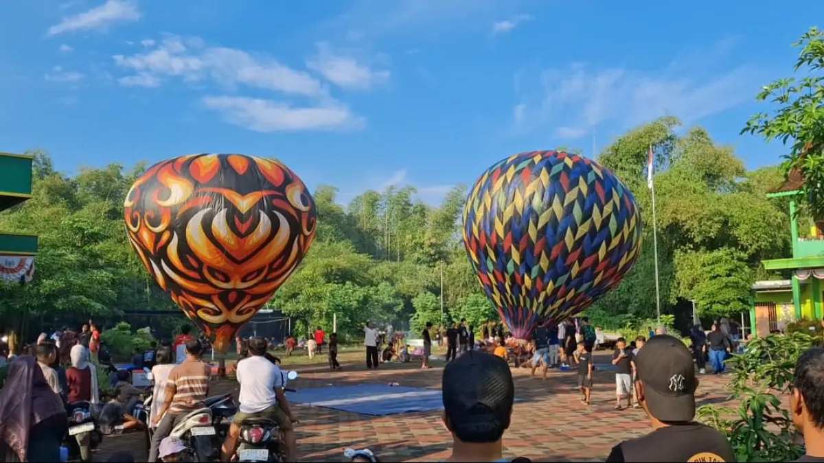 Pemuda Desa Notorejo, Kecamatan Gondang, Tulungagung, saat menaikkan balon udara warna-warni yang diberi tali.(MUSTAKIM UNTUK RADAR TULUNGAGUNG)