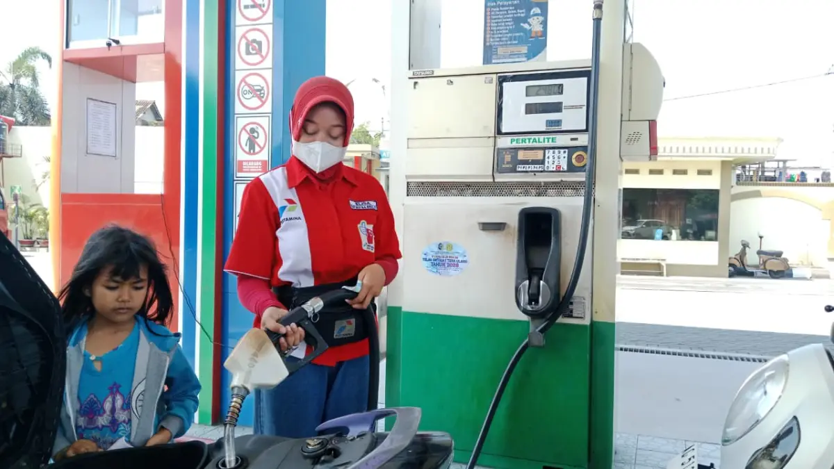 Salah satu karyawan SPBU Plosokandang melayani pengguna kendaraan bermotor kemarin sore.(RAHIIQ AL BACHRI/RADAR TULUNGAGUNG)