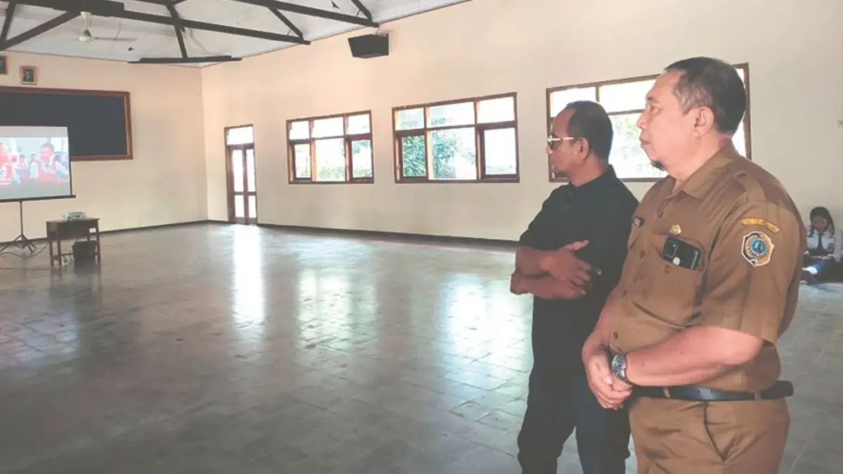 Kepala SMPN 1 Ngunut, Slamet Rihadi, bersama tim Radar Tulungagung saat mengecek kesiapan aula untuk event Edutalktif bersama Satlantas Polres Tulungagung, Senin (11/5/2026).(SANDY YUWANA/RADAR TULUNGAGUNG)