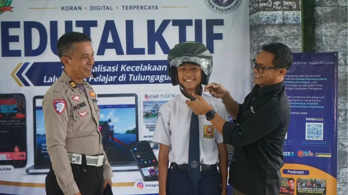 Kanit Kamsel Satlantas Polres Tulungagung Iptu Sunondo dan GM Radar Tulungagung Andrian Sunaryo saat menunjukkan kepada peserta tentang pemakaian helm yang benar untuk berkendara.
