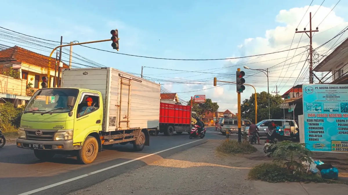 Berbagai kendaraan melintasi simpang tiga Gondang, Tulungagung, dan harus mengurangi kecepatan.(RAHIIQ AL BACHRI/RADAR TULUNGAGUNG)