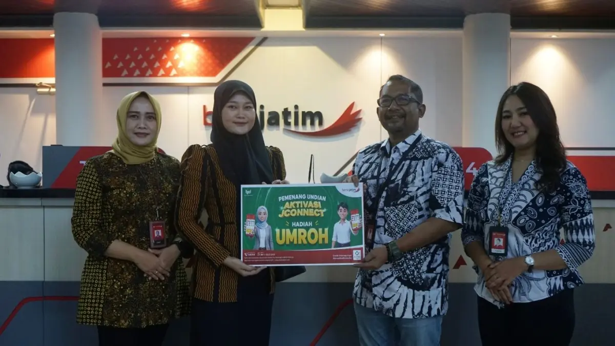 Pemimpin Bank Jatim Cabang Tulungagung, Rachmat Hadi Kusumo, menyerahkan simbolis hadiah umrah kepada Heny Retnowati, Kamis (4/6/2026).(DHIYAH AYU/RADAR TULUNGAGUNG)